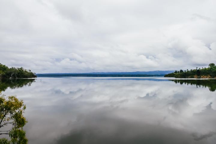 Blue lake with trees on either side