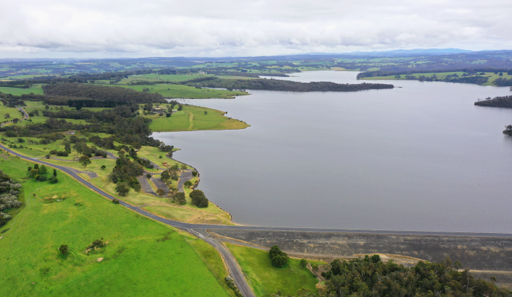 Photo taken with drone of large blue lake surrounded by trees and green hills